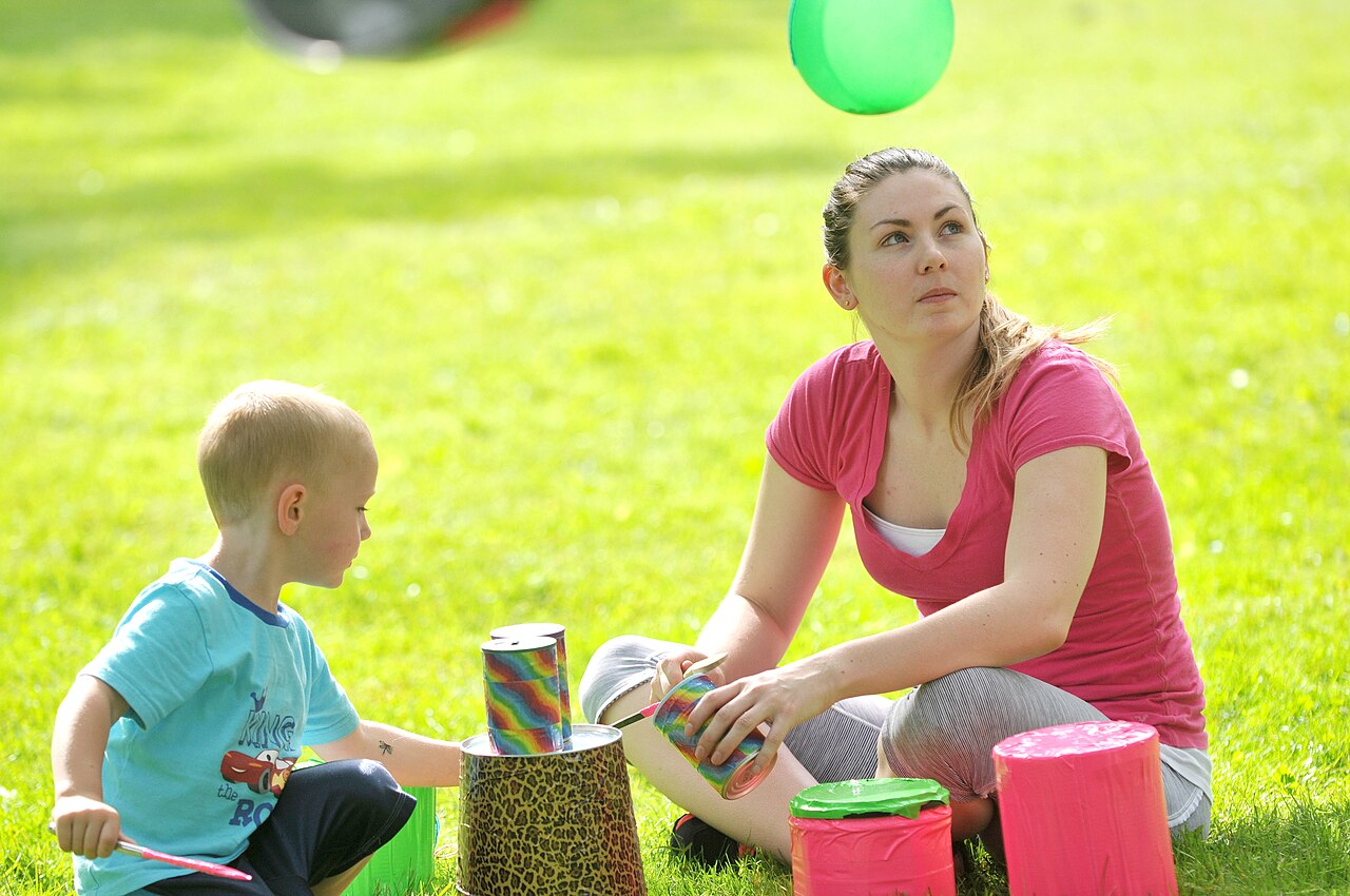 Caregiver and child playing together outdoors